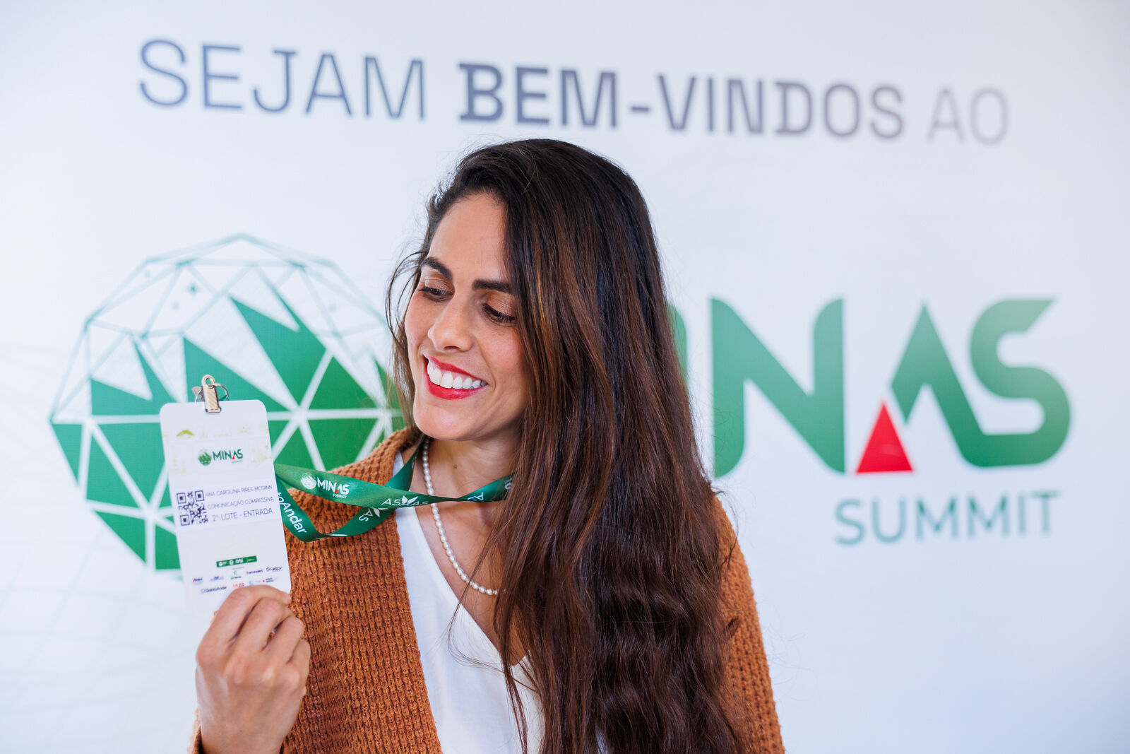 Participante com credencial no painel de boas-vindas