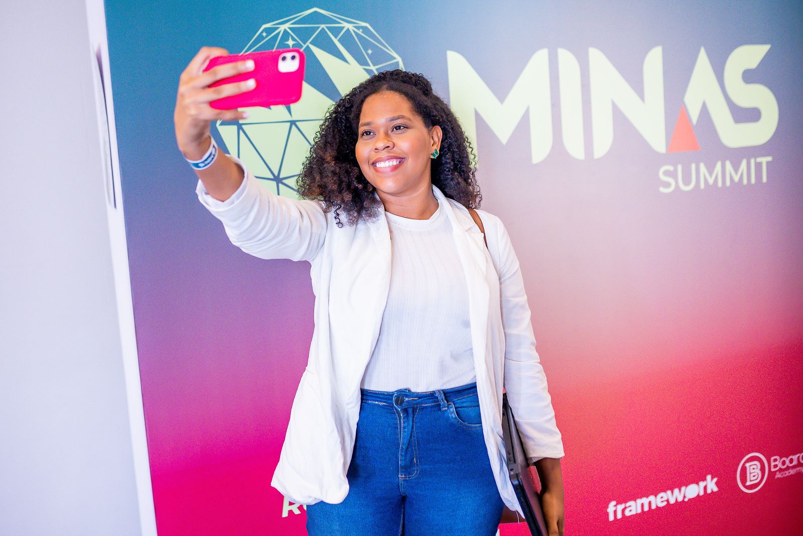 Participante em frente ao painel da marca Minas Summit